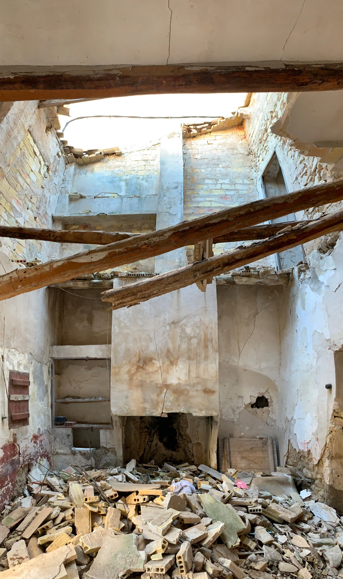 Interior deteriorado de la vivienda de Tibi con vigas de madera y escombros