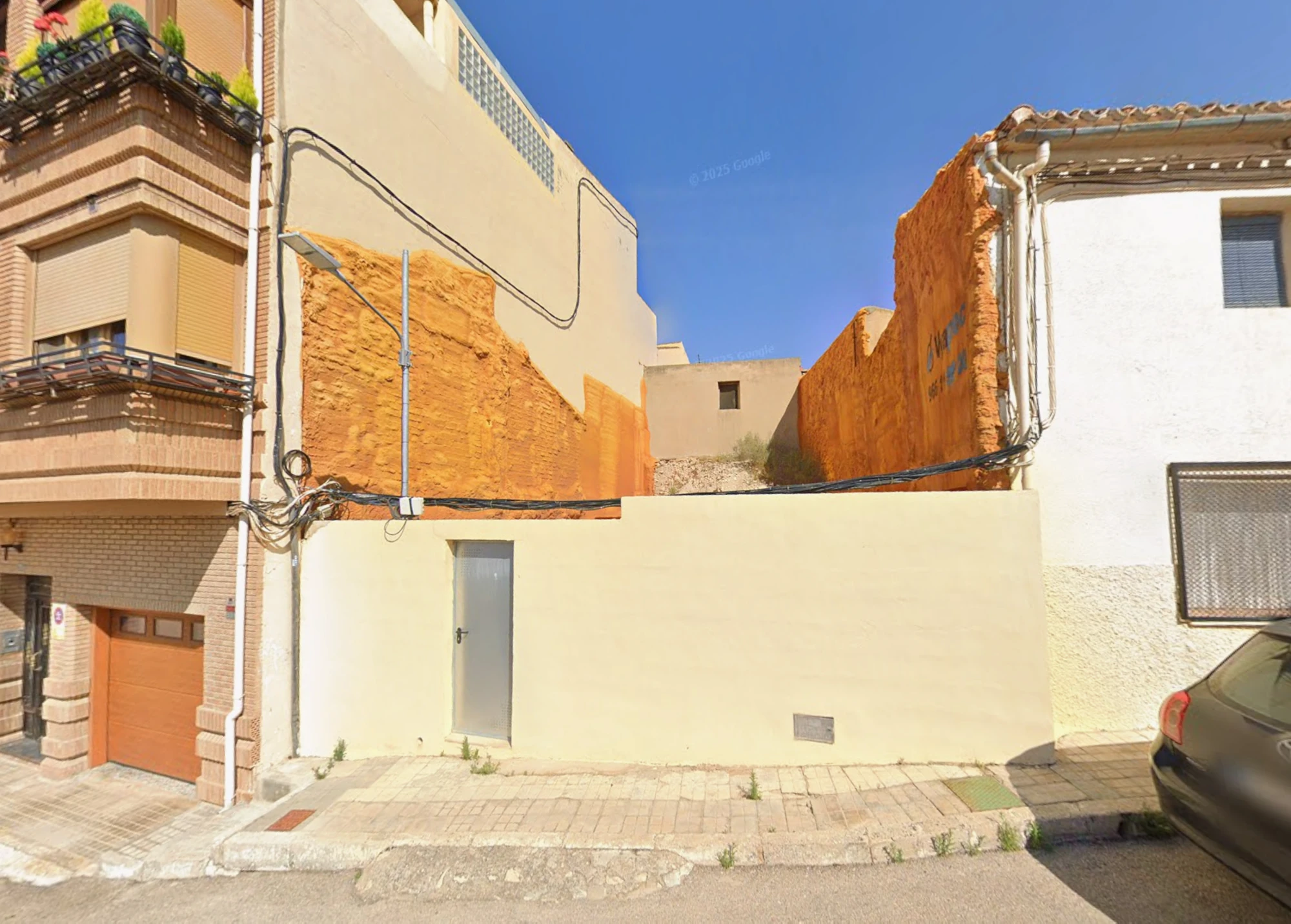 Vista posterior de la parcela de Tibi con cierre y puerta hacia la calle